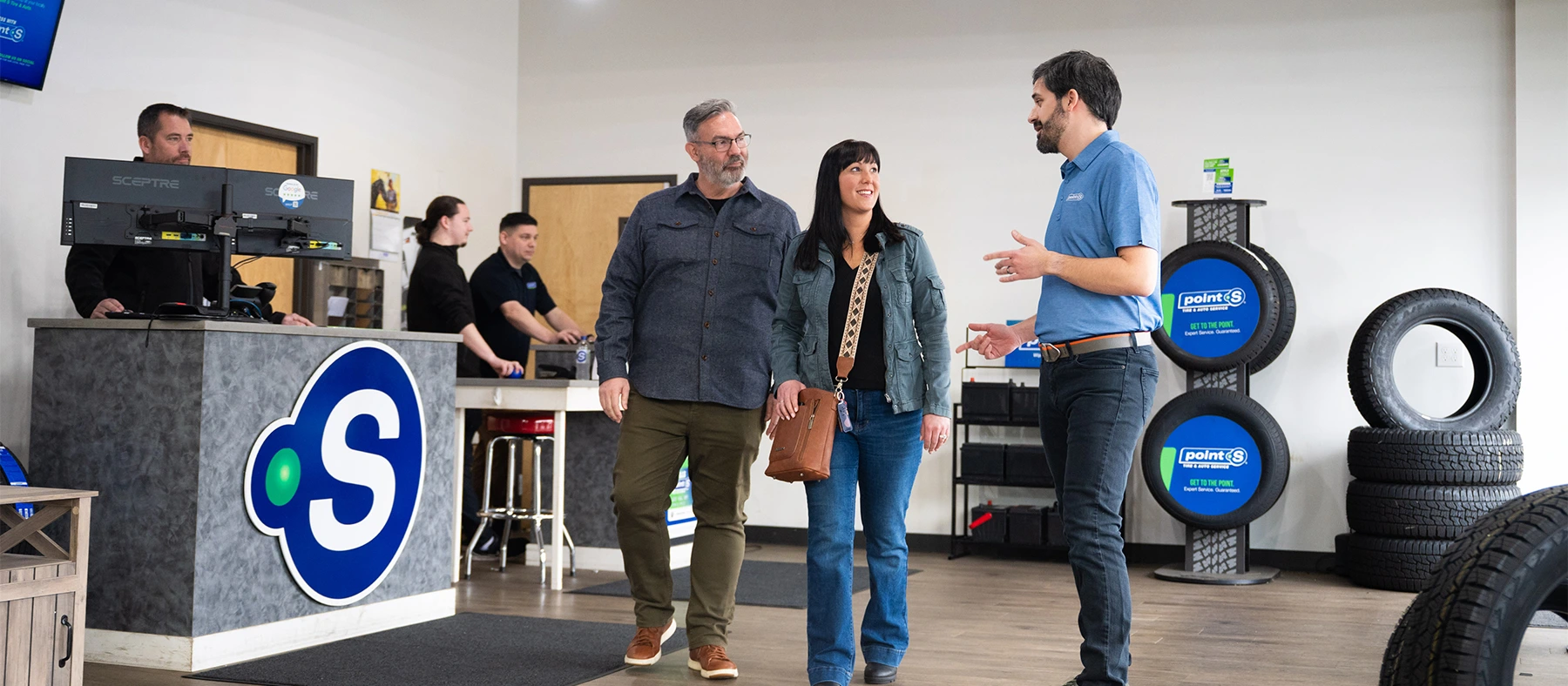 Two customers talking with a Point S team member in the showroom