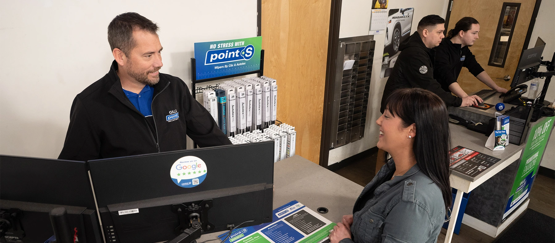 A Point S service advisor going over the Promise plan with a customer at the counter