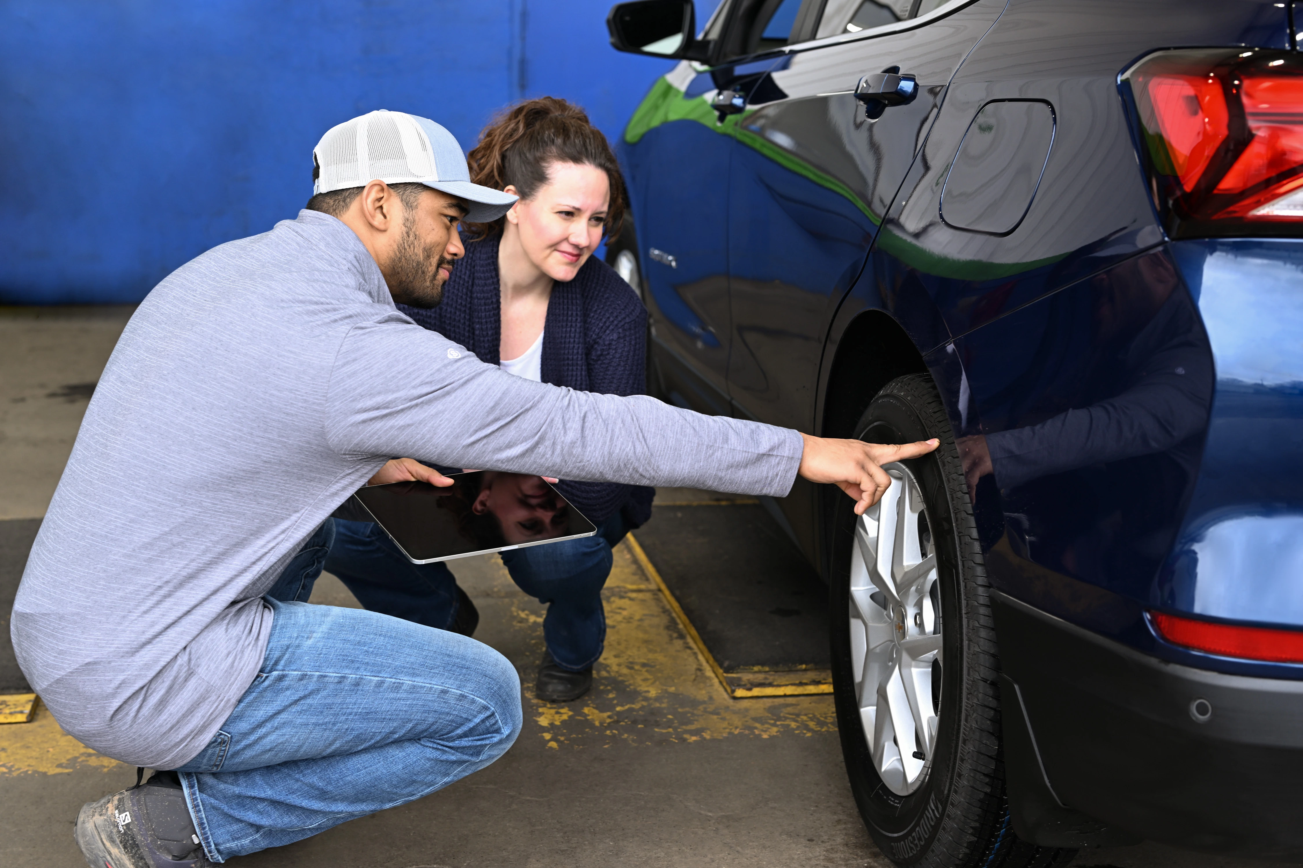 Point S team member helping a customer inspect their vehicle tires